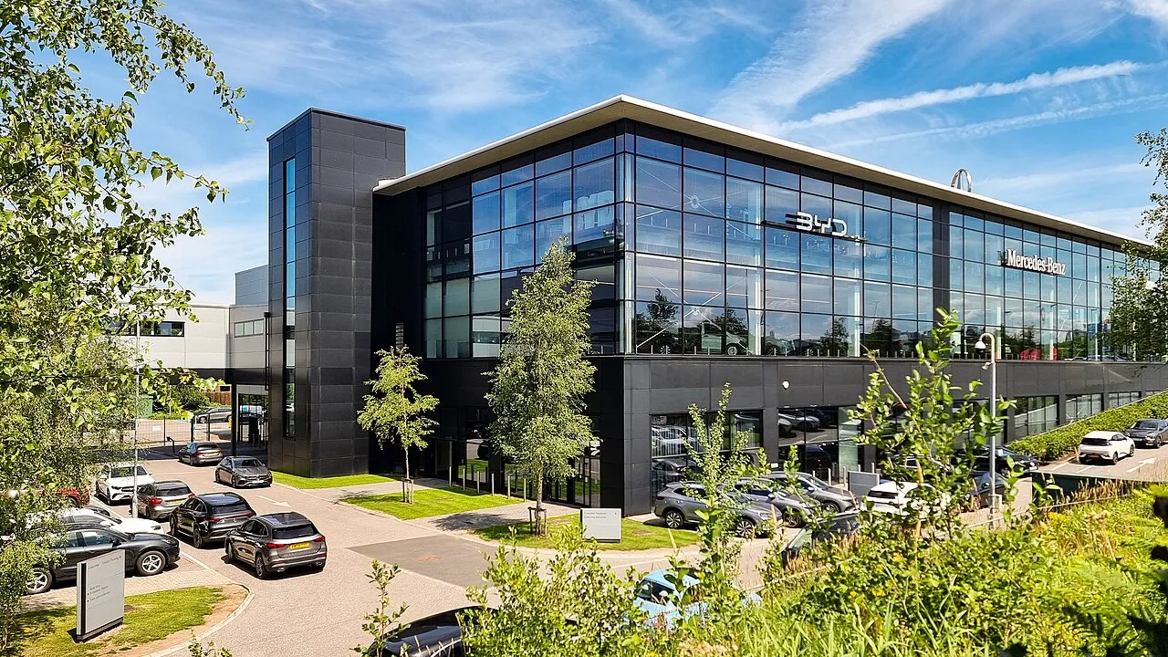 A modern car dealership building with cars outside