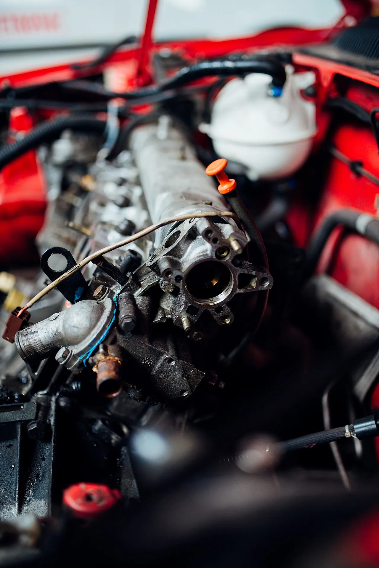 Close-up of engine parts in a red car, checked during a used car inspection